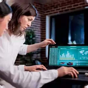 two business people’s hands next to a silver laptop